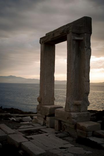The marble Portara gateway silhouetted at sunset on its islet at Naxos harbour