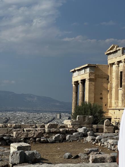 Marble columns and a pediment on the Acropolis, with Athens and the hills beyond