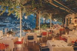 Il Tridente lit for dinner, terrace tables under the pergola at night