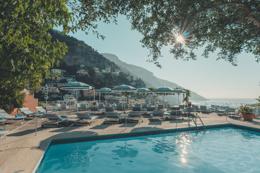 The pool and loungers on the terrace, the sea beyond