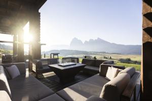 ADLER Lodge Alpe — open terrace at golden hour, Sassolungo on the horizon