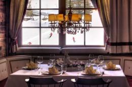 Hotel La Perla — Bistrot with crystal chandelier and a window over the ski slope