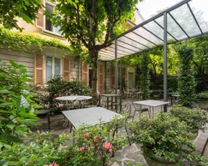 Antica Locanda Leonardo — inner garden courtyard with iron tables under a vine-covered pergola