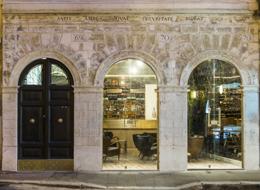 G-Rough — Via dei Sediari streetfront at night, arched windows showing the bar inside