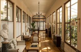 Belmond Grand Hotel Timeo — long glassed-in literary gallery with herringbone parquet, marble busts, lemon trees beyond