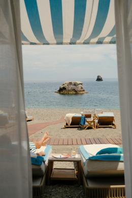 Villa Sant'Andrea — sunset terrace overlooking the umbrella-dotted beach and the Bay of Mazzarò