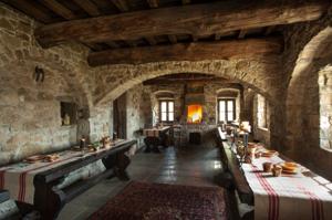Eremito — silent candlelit dinner in the stone refectory, long wooden tables and a lit fireplace