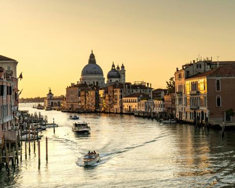 The Grand Canal at golden hour, a vaporetto and a water taxi crossing the light