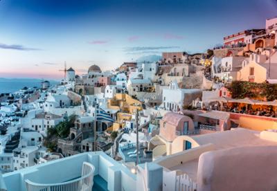 White Cycladic cliff suites at Oia, Santorini at golden hour