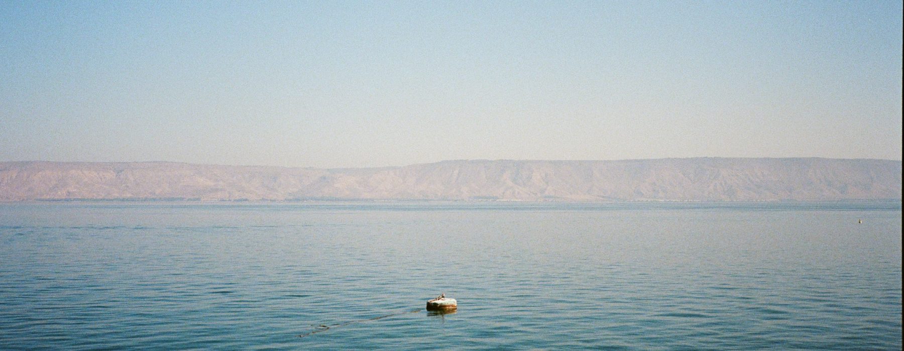 Sea of Galilee, still water and hazy mountains, Israel