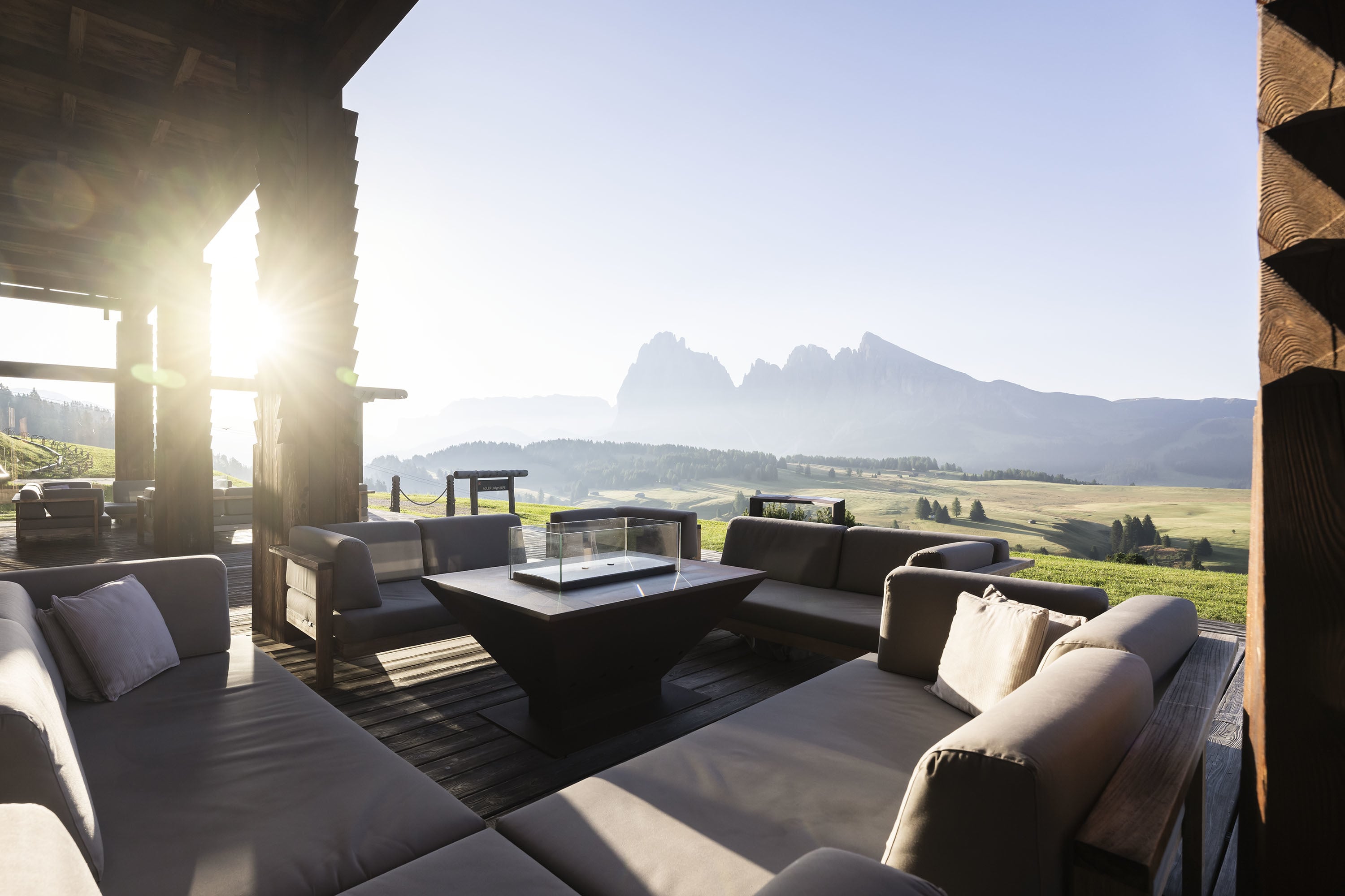 ADLER Lodge Alpe — open terrace at golden hour, Sassolungo on the horizon