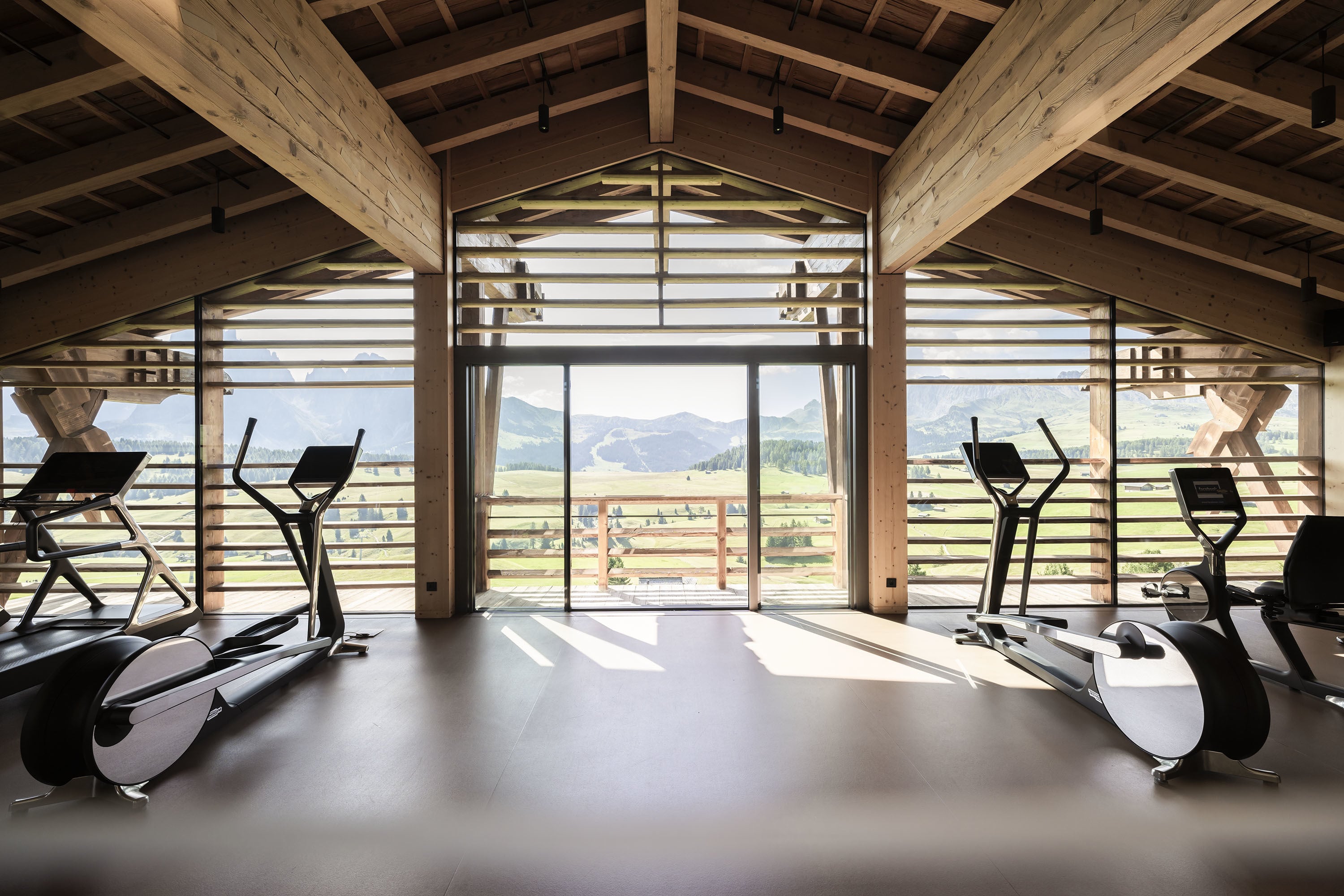 ADLER Lodge Alpe — cathedral-beam fitness pavilion with panoramic windows
