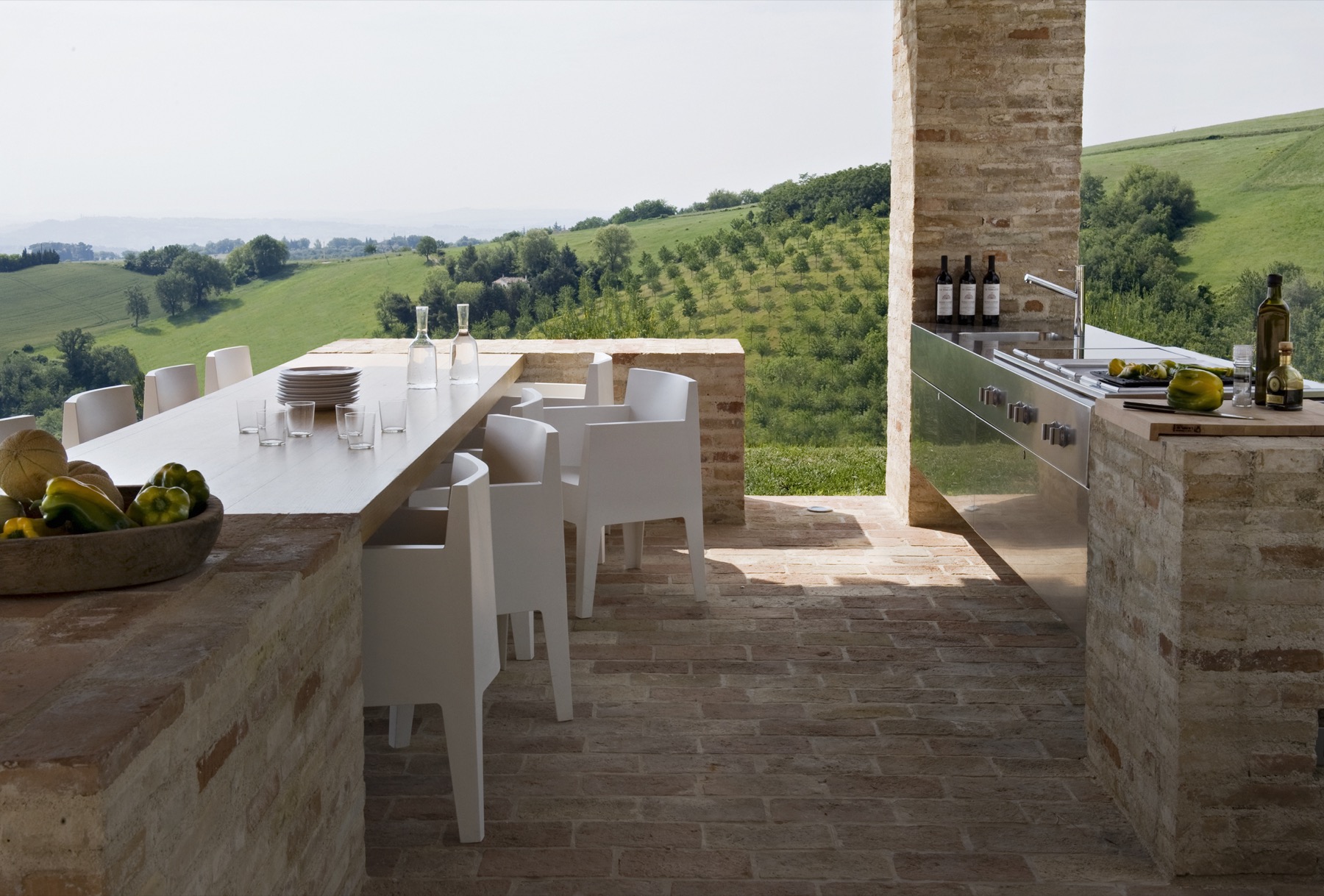 Casa Olivi — outdoor kitchen and dining table on the terrace, view to vineyards